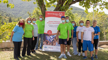 Αθλητές των Special Olympic Hellas και οι γονείς τους ποζάρουν μπροστά από πανό στη Βαμβακού
